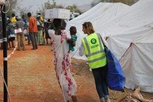 Un membre du personnel d'Oxfam aide une famille à transporter des vivres à Juba, au Soudan du Sud. Le scandale qui affecte aujourd'hui l'ONG doit-il remettre en question l'ensemble de son travail? Oxfam East Africa/Wikimedia, CC BY-ND