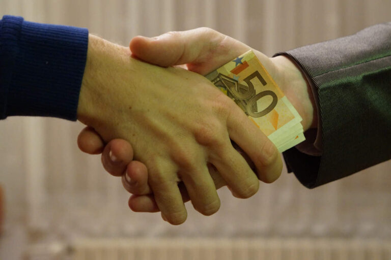 Pots-de-vin et corruption (hands_shaking_with_euro_bank_notes_inside_handshake_-_royalty_free,_without_copyright,_public_domain_photo_image_01)