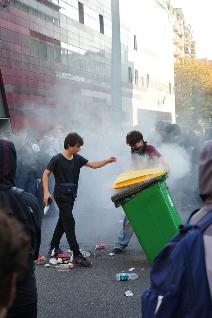 Deux lycéens tentent d'éteindre un feu de poubelle ( Camille Hestaux, CC0, via Wikimedia Commons)